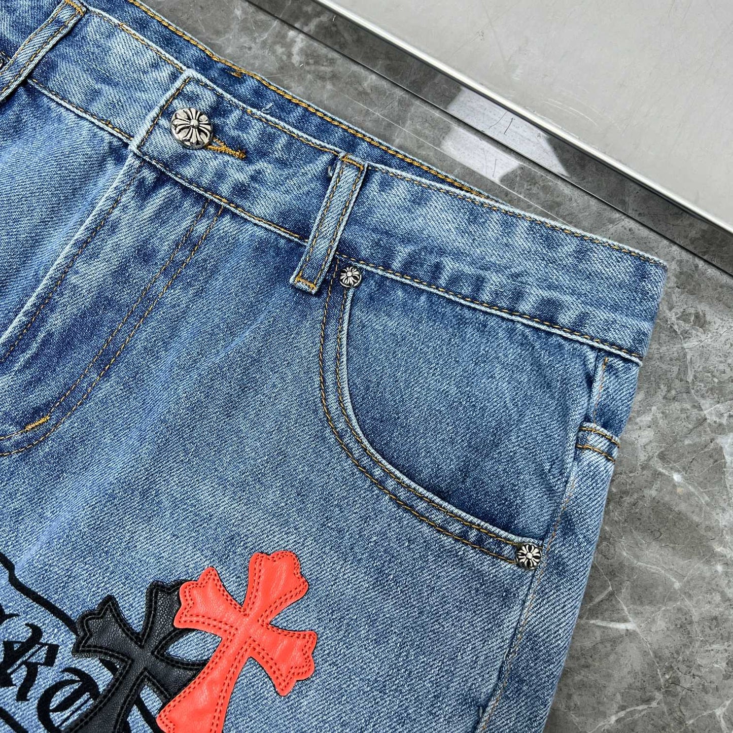 Chrome hearts jeans with black and red crosses